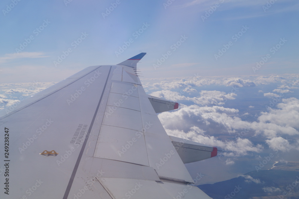 the view from the window of the aircraft, the wing of the aircraft against the sky, clouds