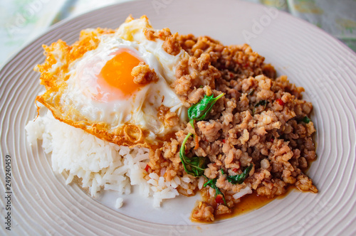 Rice topped with stir-fried pork and basil served with fried egg.