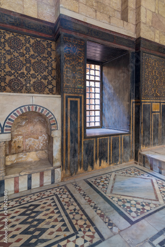 Wooden wall decorated with painted floral patterns, embedded arched niche and marble floor decorated with geometric patterns at ottoman era historic house of Moustafa Gaafar Al Seleehdar, Cairo, Egypt photo