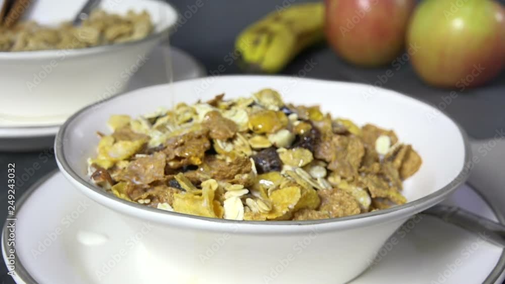 Pouring honey over a bowl of Muesli cereal slow motion Pouring honey over a bowl of Muesli cereal slow motion