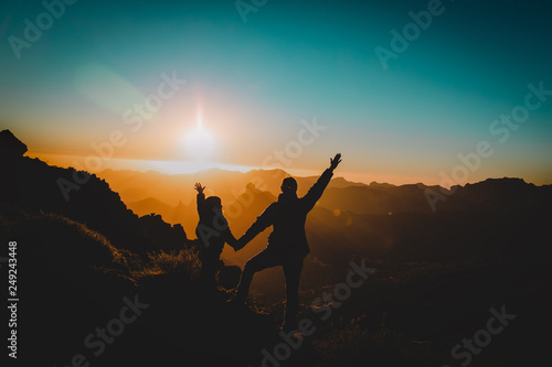 happy father and little daughter travel in mountains at sunset