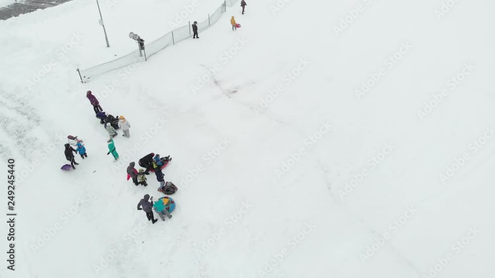 Happy people having fun on the snow in winter park. aerial survey, copter shoot Happy people having fun on the snow in winter park. aerial survey, copter shoot