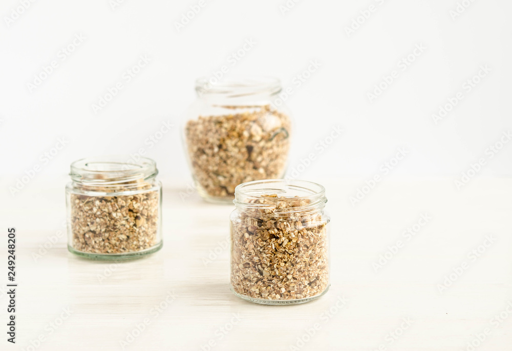 Homemade granola in a glass jar on a white background Homemade granola in a glass jar on a white background