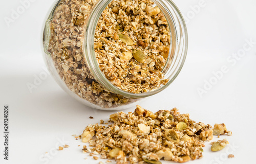 Homemade granola in a glass jar on a white background