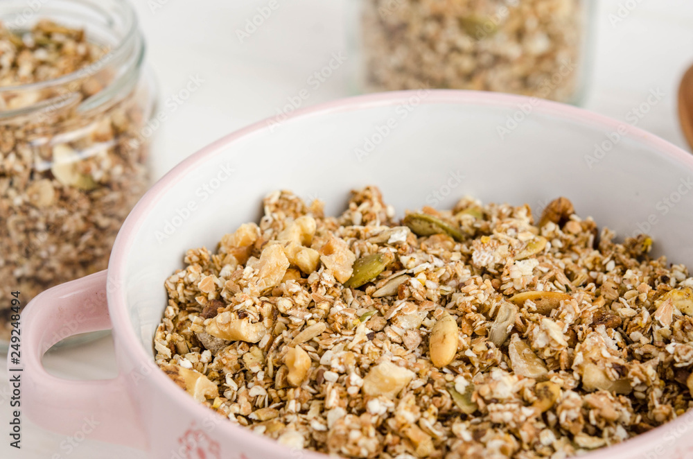 Homemade muesli in a bowl and glass jar, a bottle of milk on a white background Homemade muesli in a bowl and glass jar, a bottle of milk on a white background