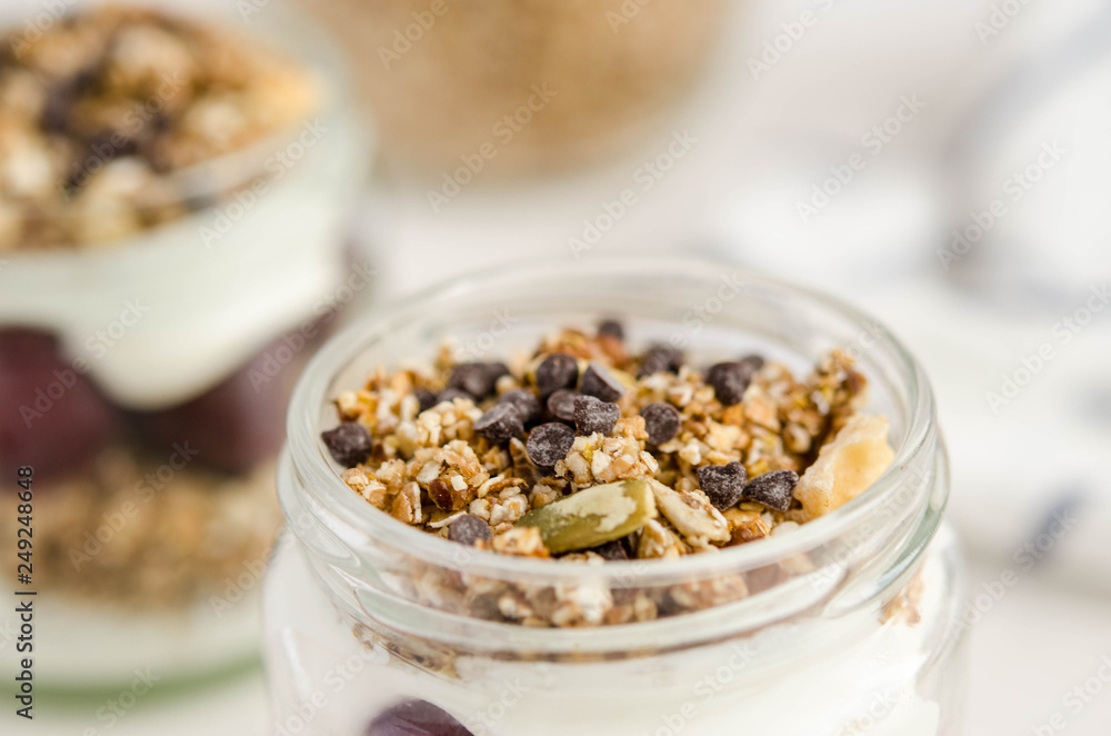 Homemade granola with cherry, yogurt in a glass jar Homemade granola with cherry, yogurt in a glass jar