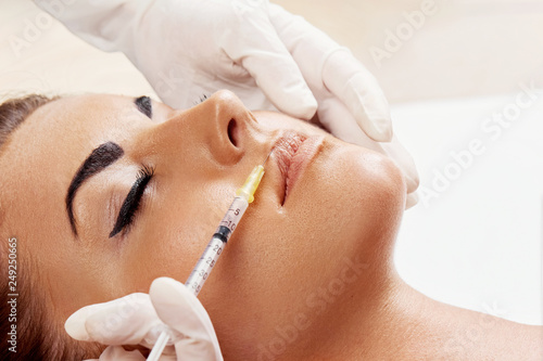 Woman getting cosmetic injection of botox in lips, closeup. Girl in beauty salon. plastic surgery clinic.Facelift.