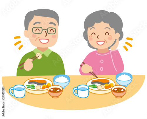 食事をする年配の男女