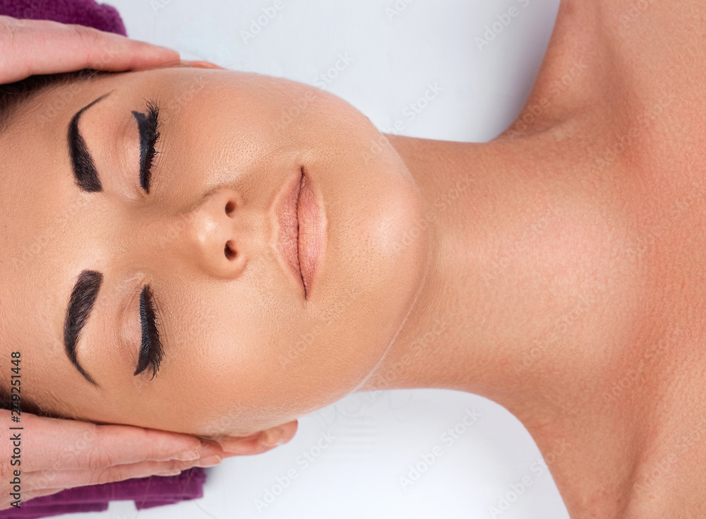 Face massage. Close-up of young woman getting spa massage treatment at beauty spa salon.Spa skin and body care. Facial beauty treatment.Cosmetology.Relaxing Face massage. Close-up of young woman getting spa massage treatment at beauty spa salon.Spa skin and body care. Facial beauty treatment.Cosmetology.Relaxing