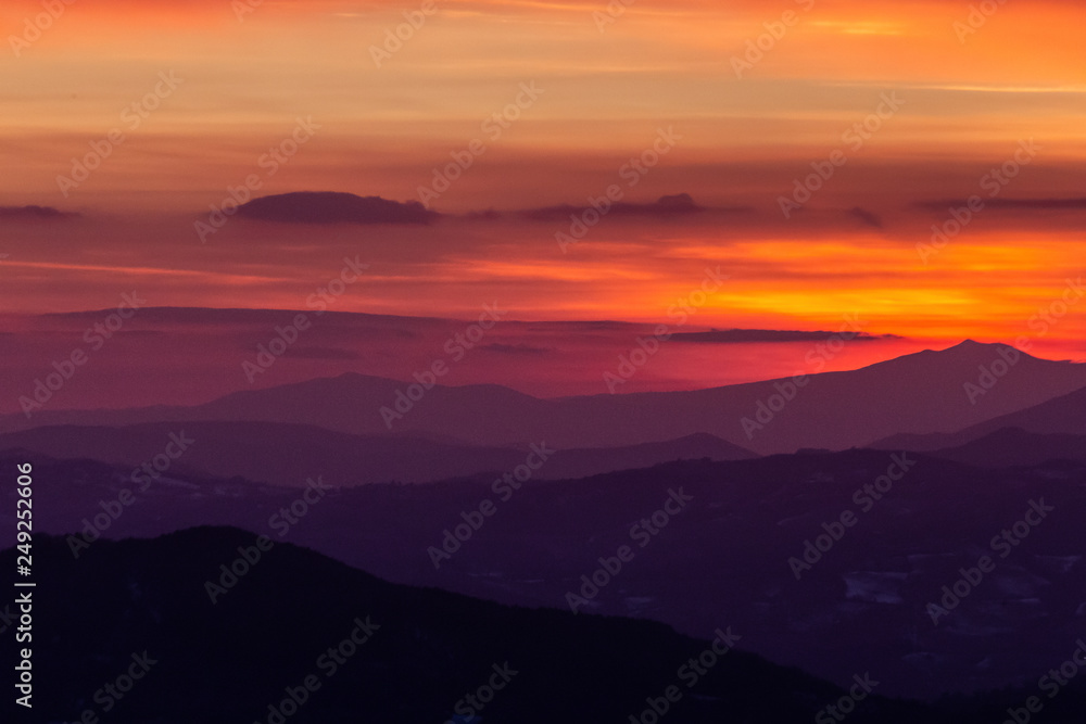 Beautifully colored sky at dusk, with mountains layers