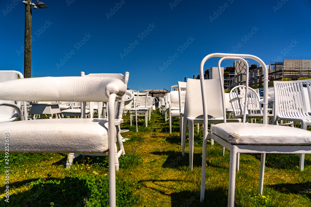 An installation of empty white chairs constitutes an unofficial