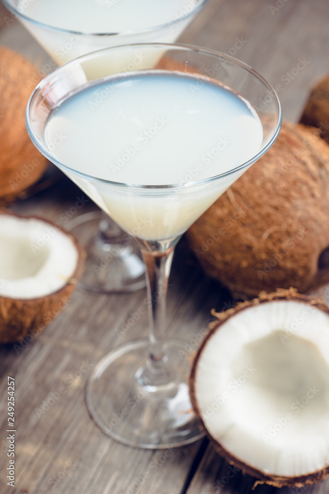 Sweet coconut cocktail in martini glass on the wooden background. Selective focus. Shallow depth of field. Sweet coconut cocktail in martini glass on the wooden background. Selective focus. Shallow depth of field.