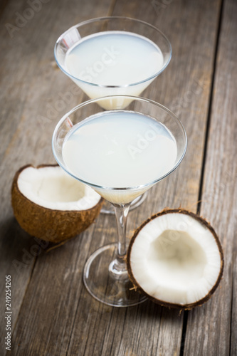 Sweet coconut cocktail in martini glass on the wooden background. Selective focus. Shallow depth of field. 