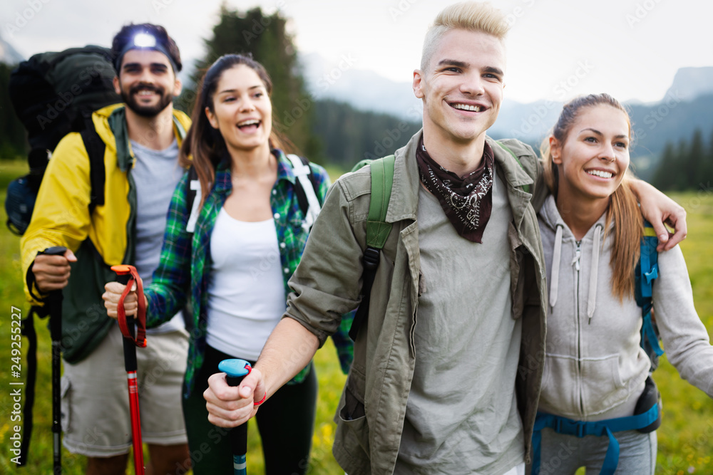 Group of hikers walking on a mountain and smiling Group of hikers walking on a mountain and smiling