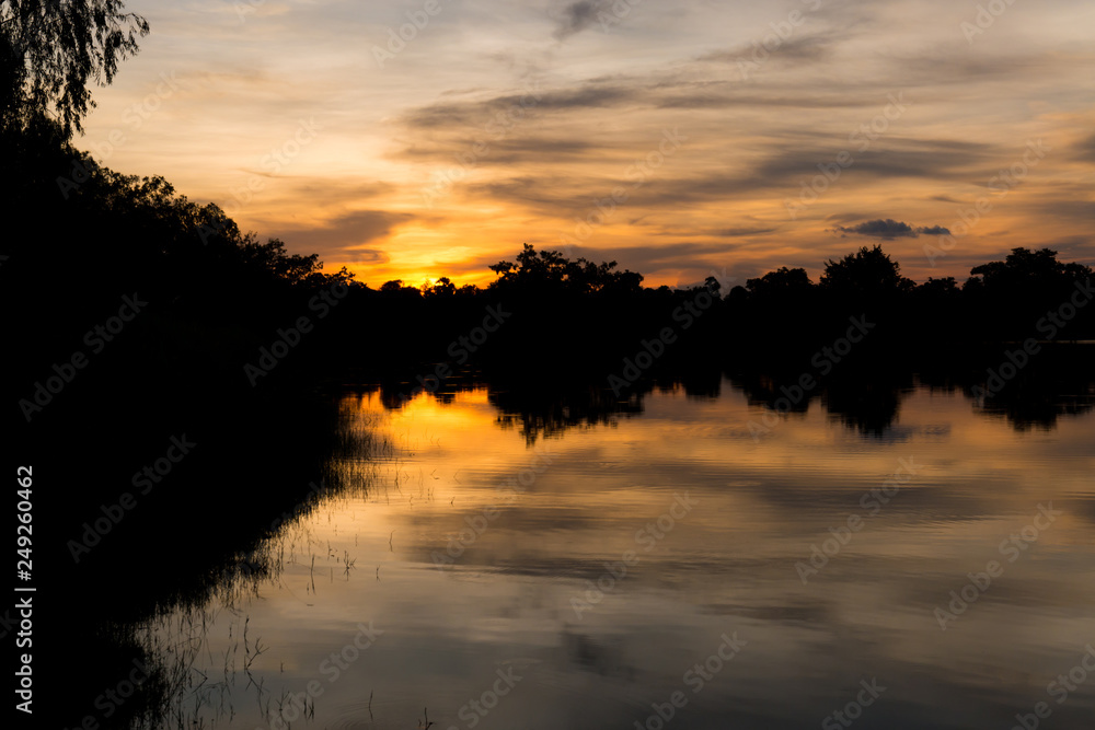 Fototapeta premium Silhouette of a trees at the lake in sunset with beautiful reflection.