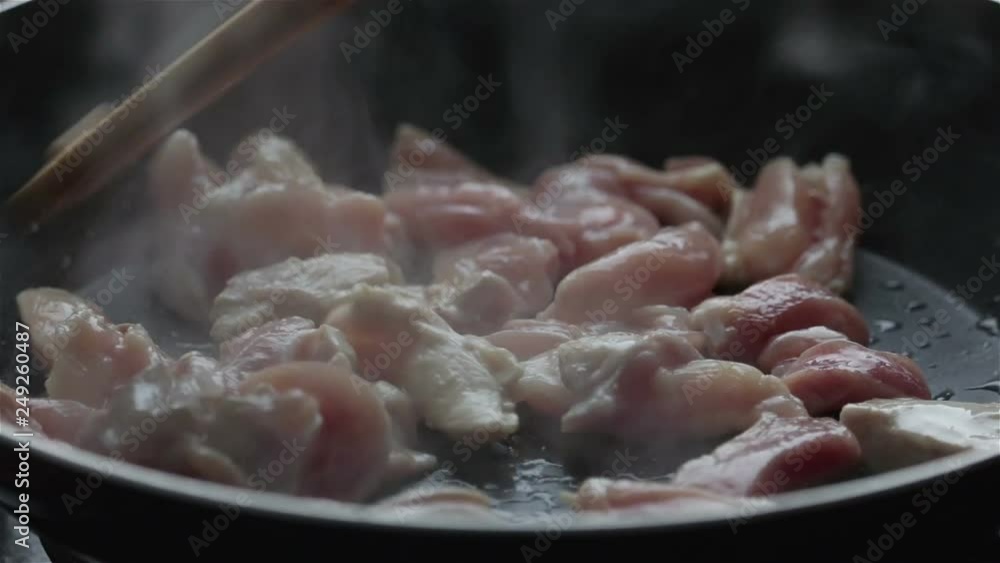 cooking raw chicken meat frying in pan close up