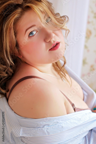 Sexy and beautiful plus size girl in lingerie and an open white shirt.