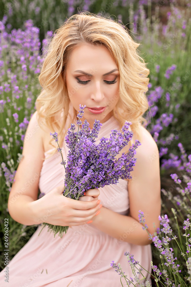 Pretty girl in a lavender field holding a bouquet of lavender. Pretty girl in a lavender field holding a bouquet of lavender.