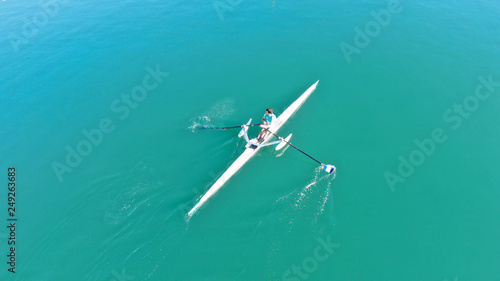 Aerial drone photo of young man practising sport canoe in tropical port with calm sea