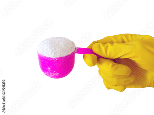 Employee hand in rubber protective glove with pink cup or scoop . Getting started cleaning.  Commercial cleaning company. Copy space. Detergent for clothes washing. Regular washing.