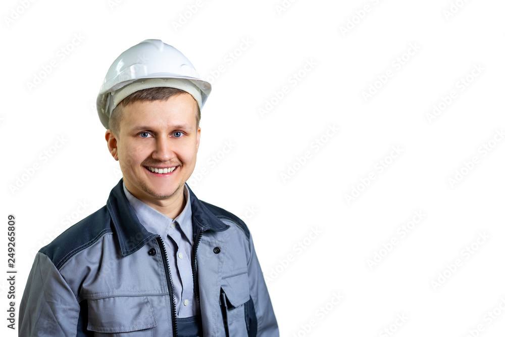 Portrait of a young engineer worker in a white helmet. He is happy and smiling at the camera. Possible career advancement. isolated. Close-up Portrait of a young engineer worker in a white helmet. He is happy and smiling at the camera. Possible career advancement. isolated. Close-up