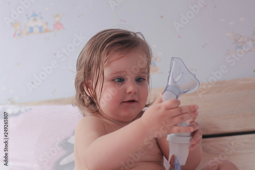 Baby girl playing with inhaler. photo