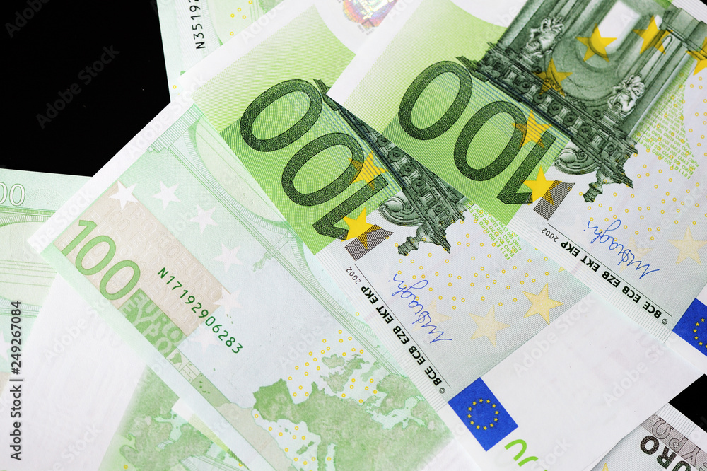 One Hundred euro banknotes on a dark background close up One Hundred euro banknotes on a dark background close up