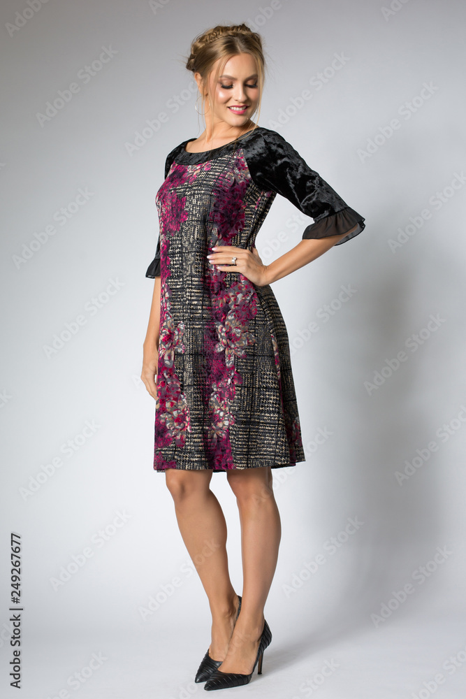 Blonde woman posing in long dress with flowers design Blonde woman posing in long dress with flowers design