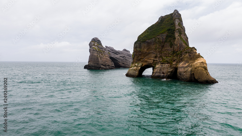 Rippled Sand and rock formations at Wharariki Beach from above, Nelson, North Island, New Zealand, Archway Islands in the ocean, Natural wallpaper background, aerial photography amazing rock formation
