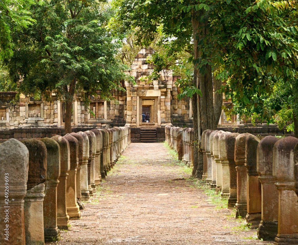 Laterite stone paved walkway with stone posts to the gates of 11th-century ancient Khmer temple Prasat Sdok Kok Thom in Sa Kaeo province of Thailand
