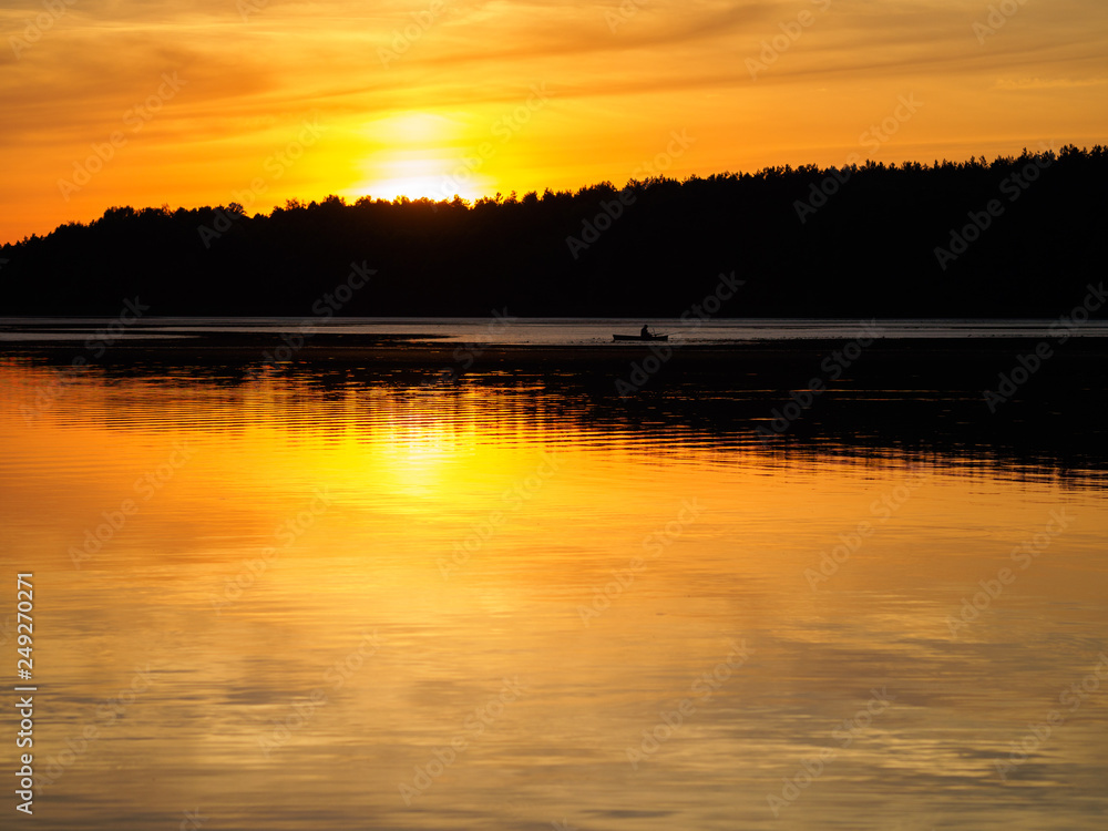 Boat sailing in the distance at sunset. Silhouette of a boat on the river Boat sailing in the distance at sunset. Silhouette of a boat on the river