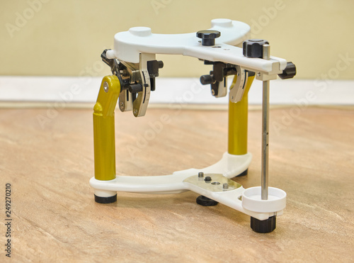 Dental technician working with articulator in dental lab