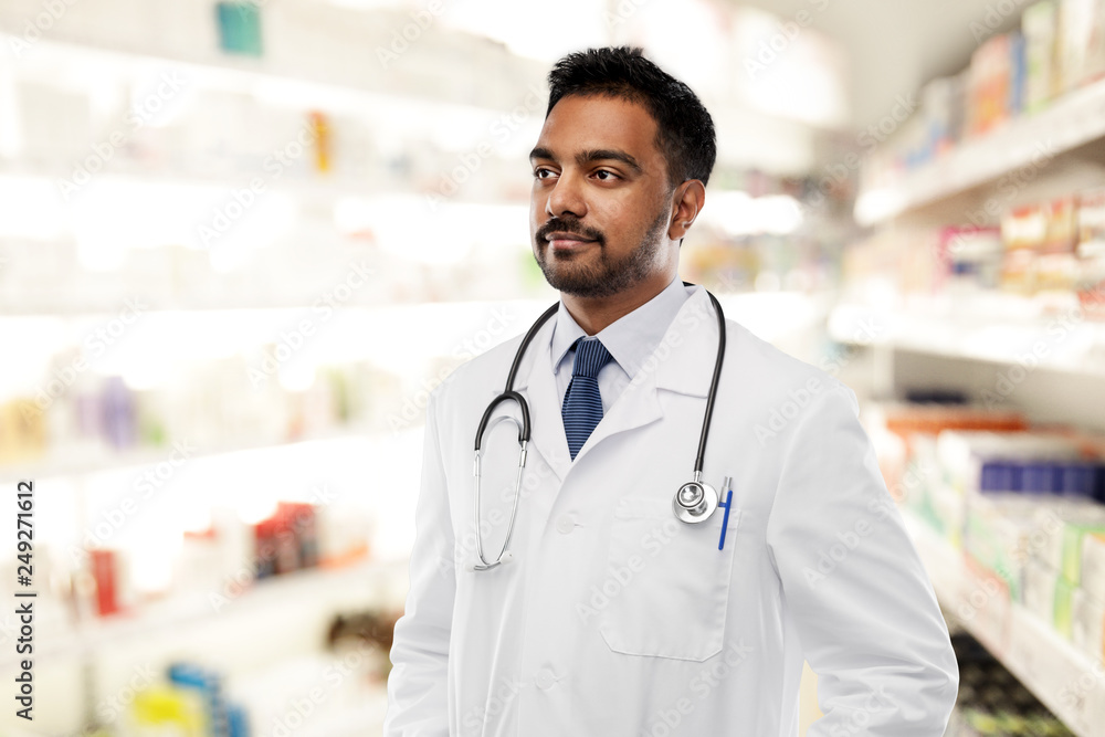 medicine, pharmacy and healthcare concept - indian male doctor or pharmacist with stethoscope over drugstore background medicine, pharmacy and healthcare concept - indian male doctor or pharmacist with stethoscope over drugstore background