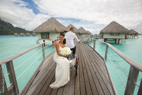 Beautiful wedding couple posing on dock near houses at Bora Bora