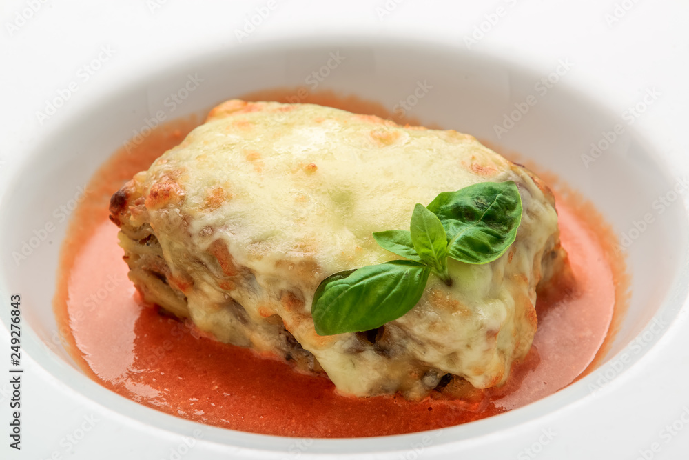 Close-up of a traditional lasagna made with minced beef bolognese sauce topped with basil leafs served Close-up of a traditional lasagna made with minced beef bolognese sauce topped with basil leafs served