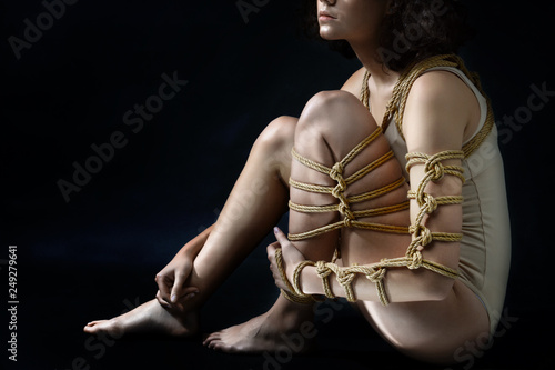 Submission slave woman bound in erotic fashion art style rope shibari kinbaku Japanese bondage knot. Bdsm sadomasochism mistress master dominant fetish punishment flogging sadism masochism concept.