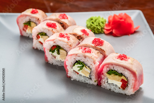 Salmon, tuna, sushi rolls set. On wooden background