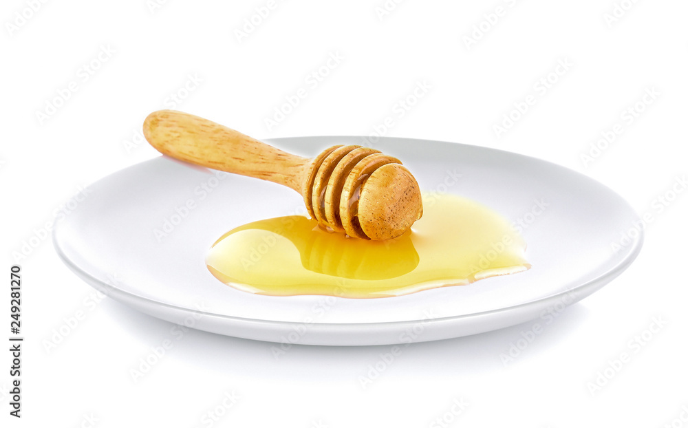 Wooden honey dipper with honey white plate on white background Wooden honey dipper with honey white plate on white background