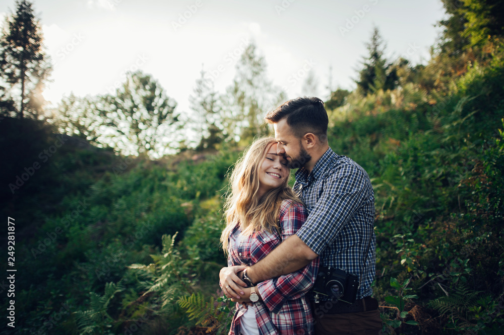 Young couple in love outdoor. Travelers couple look at the mountain. Young couple in love outdoor. Travelers couple look at the mountain.