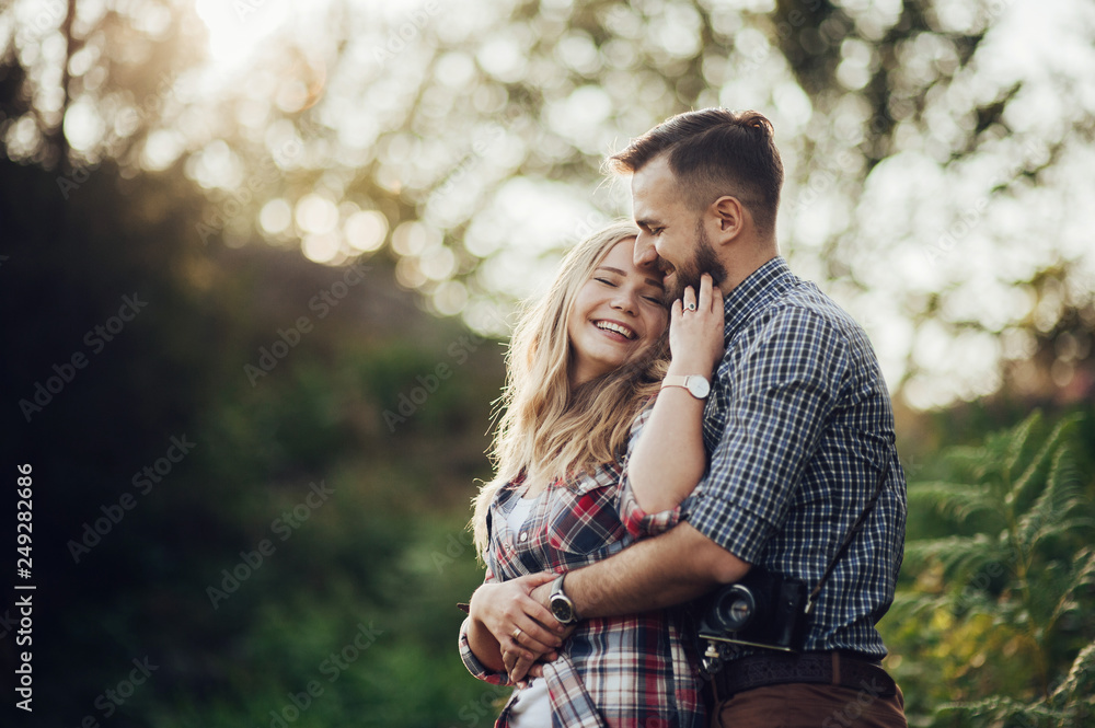 Fototapeta premium Young couple in love outdoor. Travelers couple look at the mountain.
