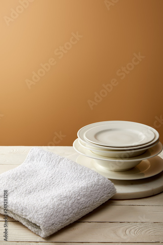stack of plates and terry cotton towel on white wooden surface