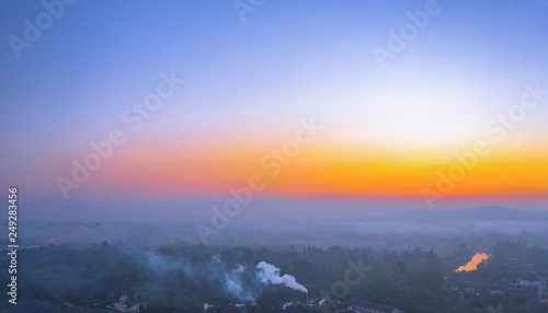 aerial photography smoked from industry blowing during sunrise above mountain in Surat Thani Thailand.. photo