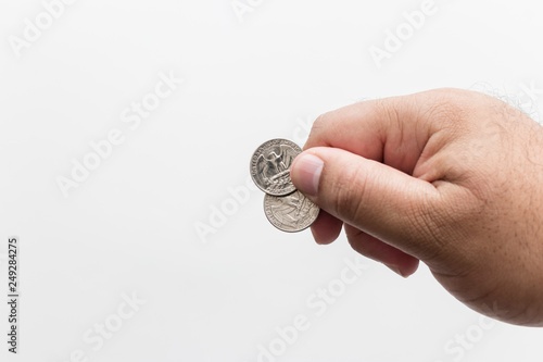 Male hand holding two quarter dollar coins, white background