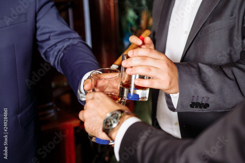three men clink glasses