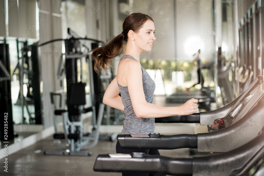 Pretty young sport woman is running on treadmill in gym, Healthy lifestyle Pretty young sport woman is running on treadmill in gym, Healthy lifestyle