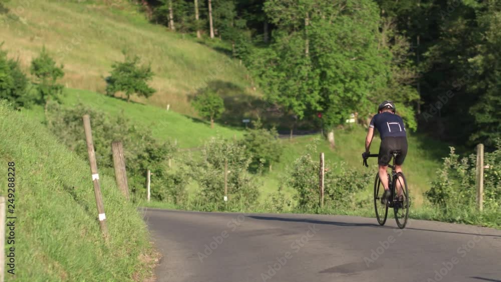 Cyclist on the road among the delightful Alpine landscape in the Swiss mountains. Cyclist on the road among the delightful Alpine landscape in the Swiss mountains.