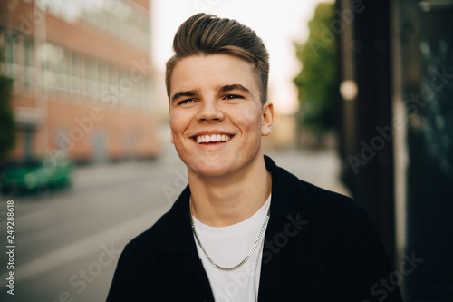 Smiling man walking on sidewalk in city photo