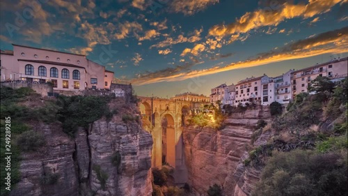 Timelapse of the Puente Nuevo bridge and the houses built on the edge of the cliff at dusk, in the ancient city of Ronda, Spain. photo