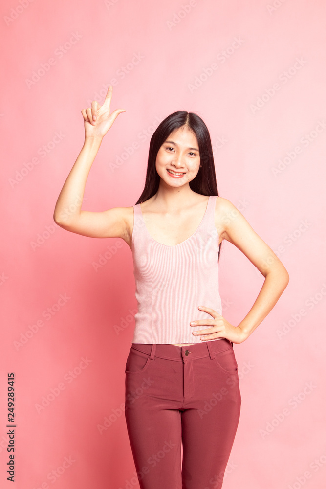 Young Asian woman smile and point up.