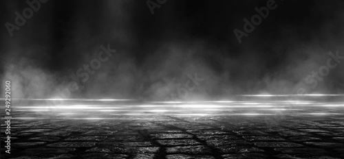 Wet asphalt, reflection of neon lights, a searchlight, smoke. Abstract light in a dark empty street with smoke, smog. Dark background scene of empty street, night view, night city. photo